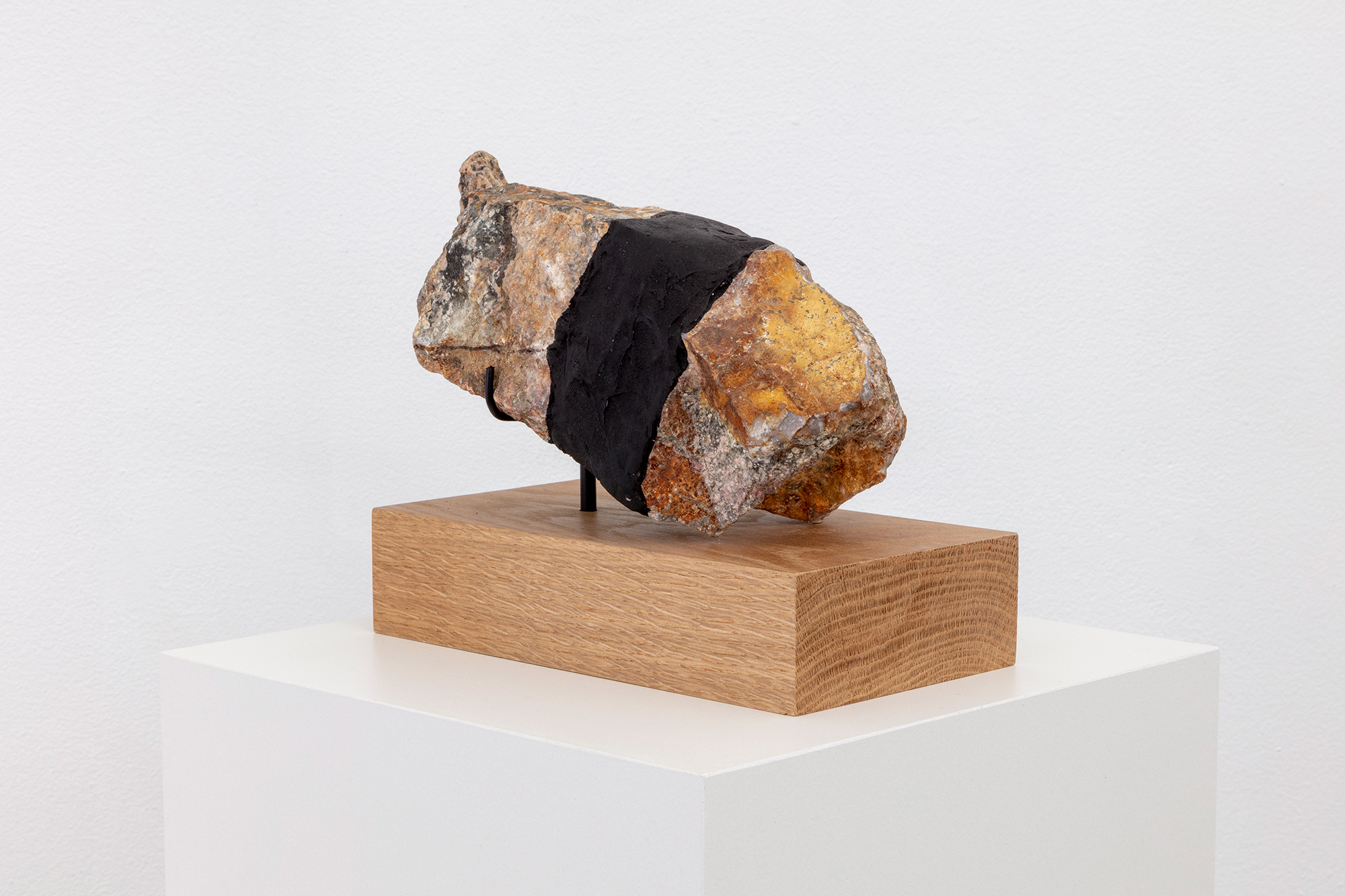 Sculpture with rock on wooden pedestal