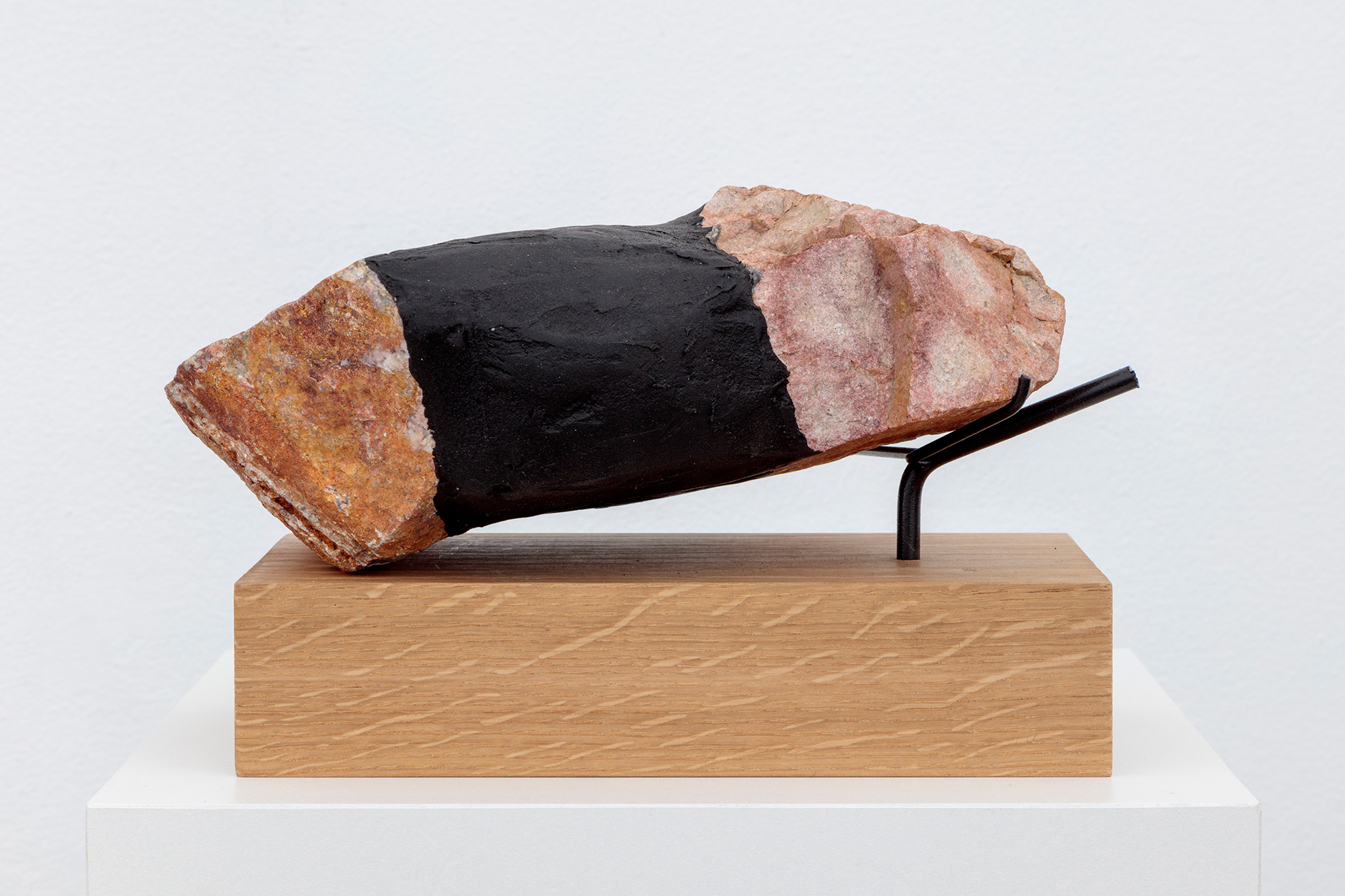 Sculpture with rock on wooden pedestal