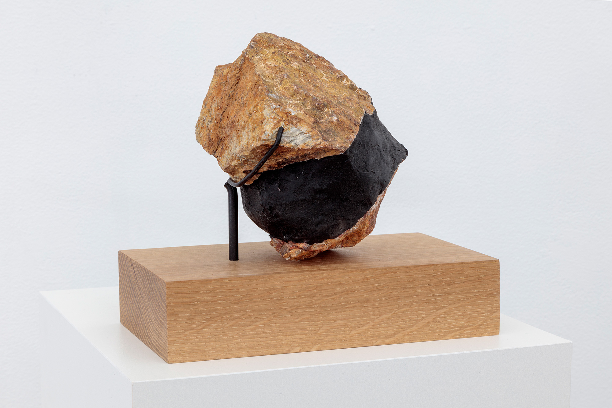 Sculpture with rock on wooden pedestal