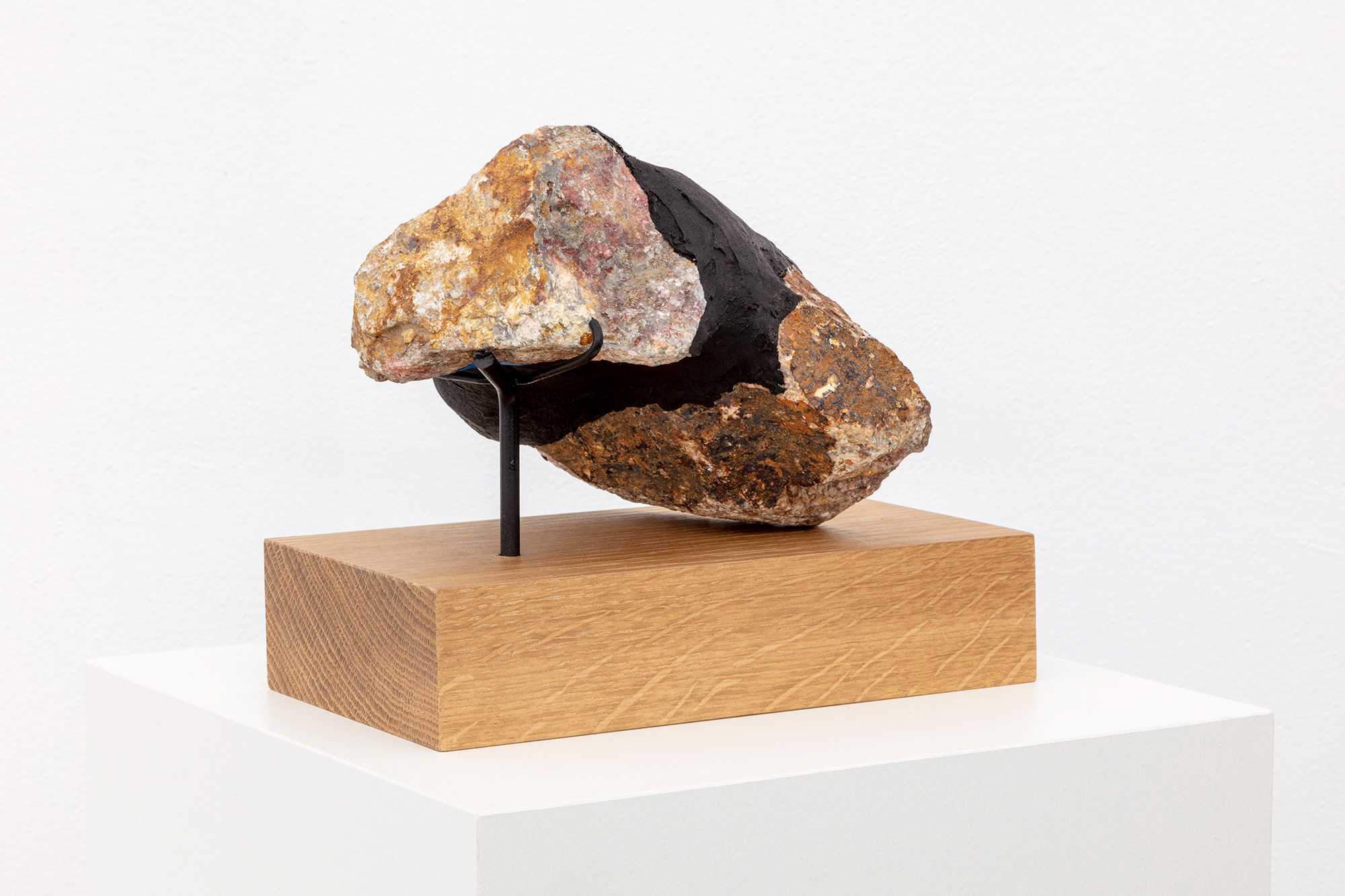 Sculpture with rock on wooden pedestal
