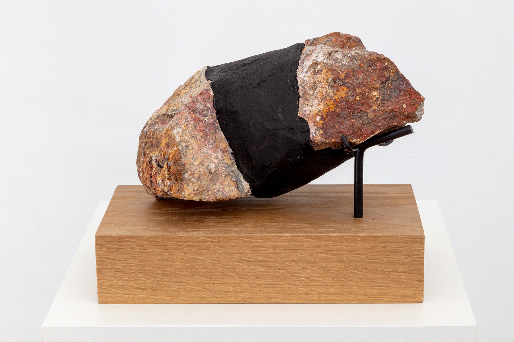 Sculpture with rock on wooden pedestal