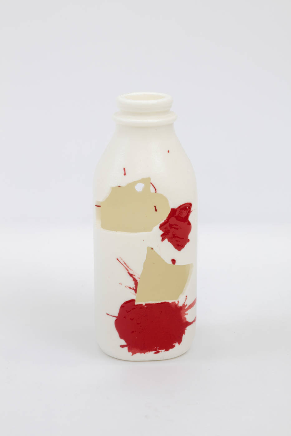 Bottle sculpture with splashes of cream and red color