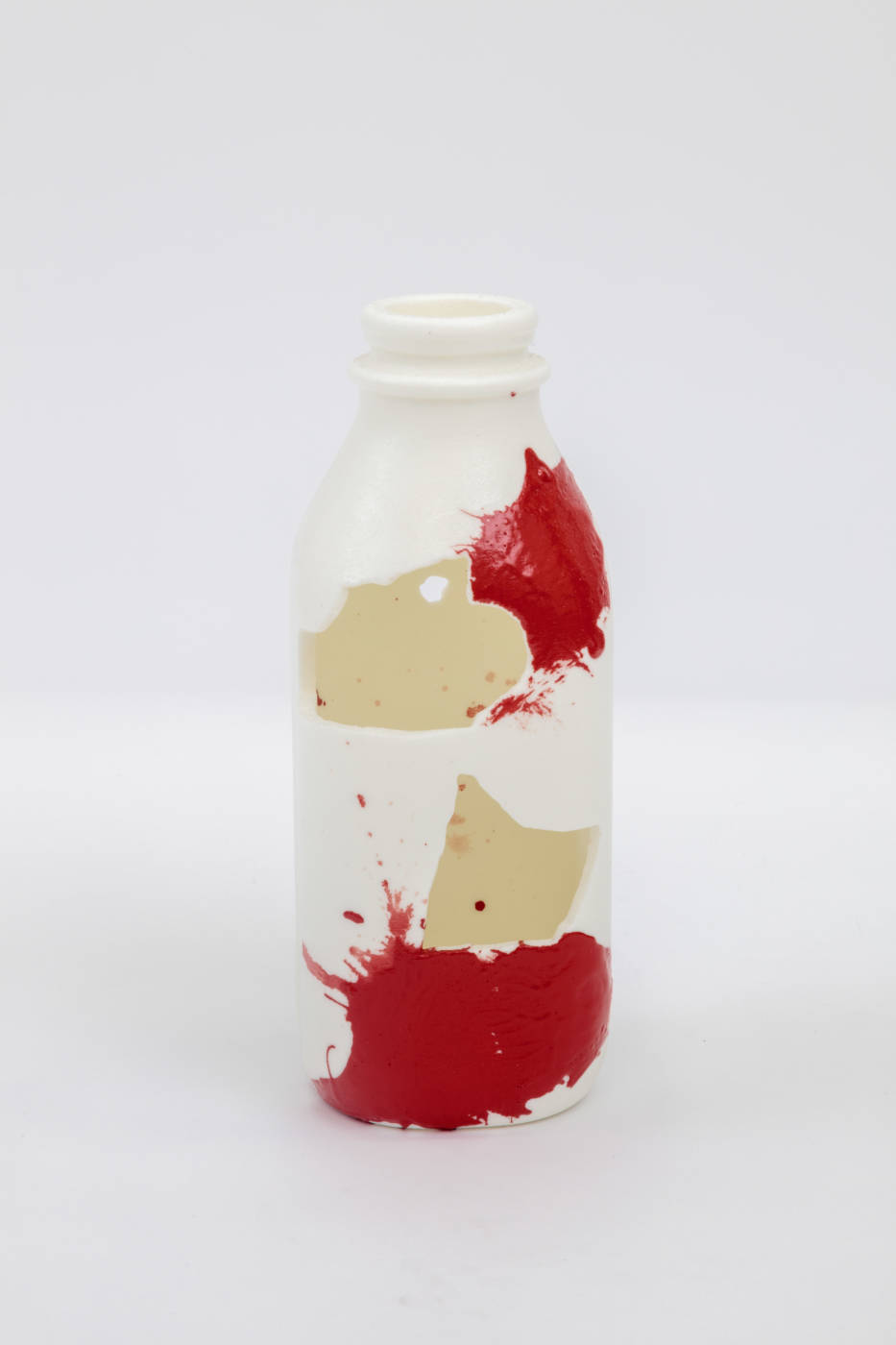 Bottle sculpture with splashes of cream and red color