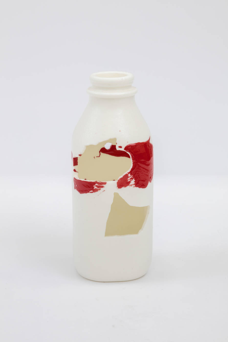 Bottle sculpture with splashes of cream and red color