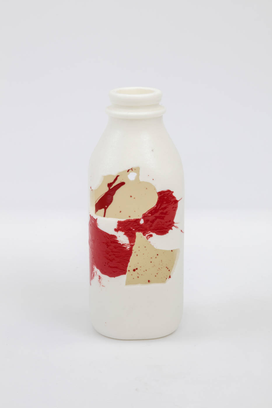 Bottle sculpture with splashes of cream and red color