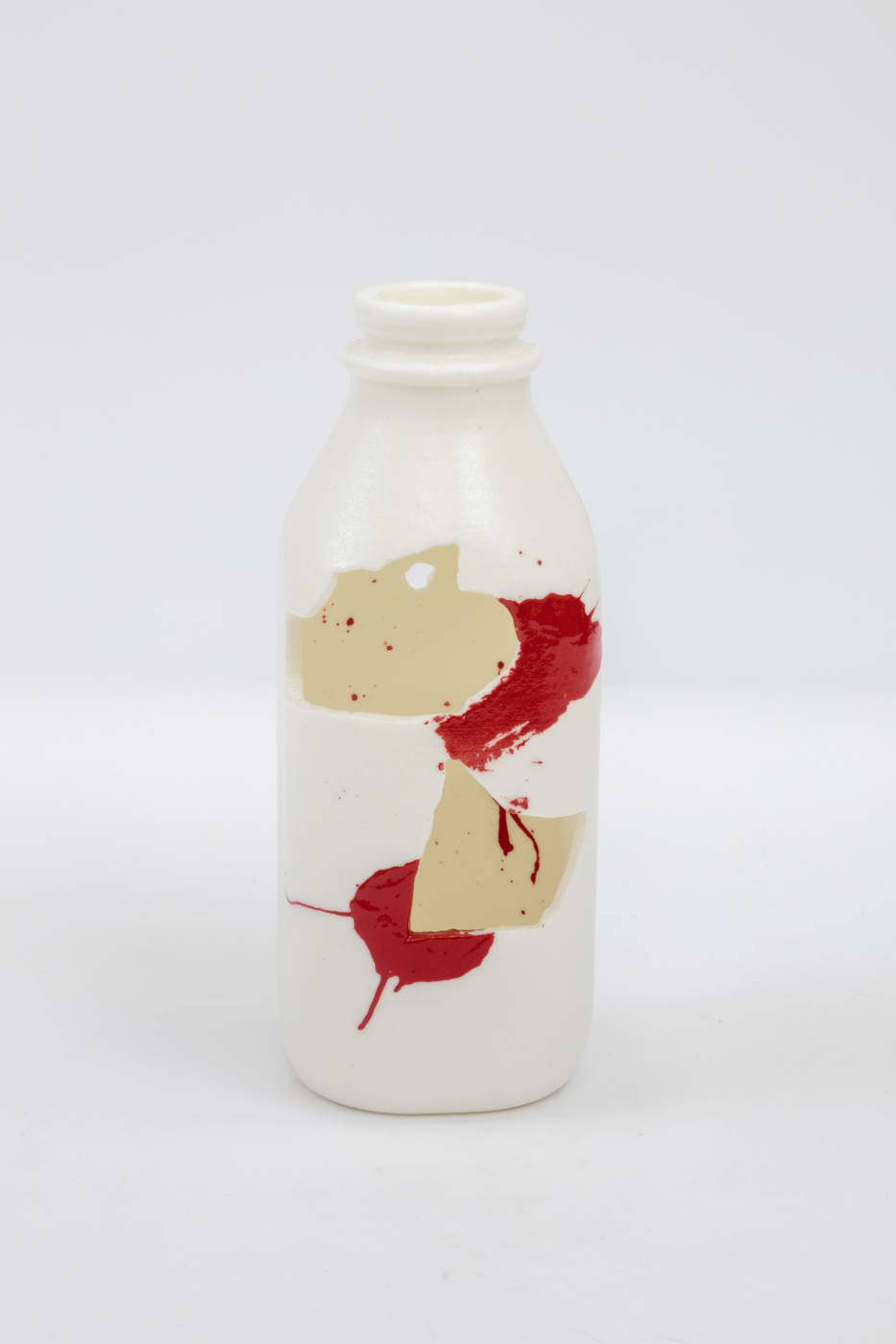 Bottle sculpture with splashes of cream and red color