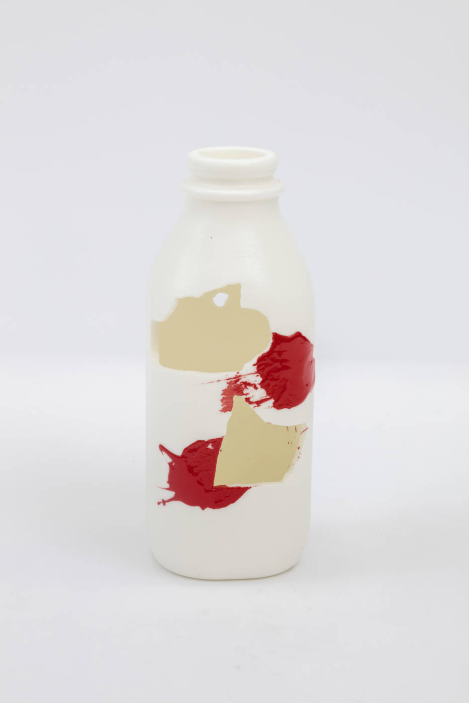 Bottle sculpture with splashes of cream and red color